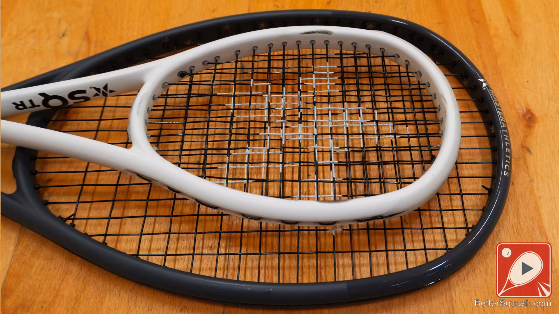 Two Master Athletics Squash rackets lying flat on the floor showing the head size comparison